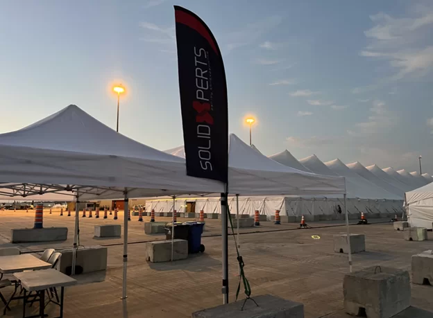 A Solidxperts team banner outside the team tent at the Make-a-Wish 48-Hour Bike Ride event at ICAR racetrack.
