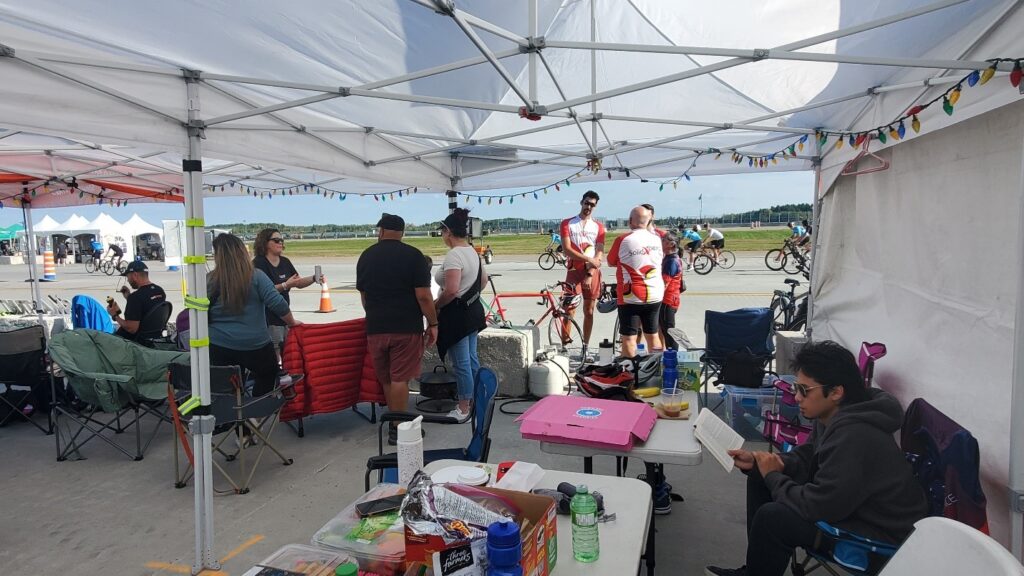 Solidxperts team relaxing in the team tent between relay race stints at the 2024 Make-a-Wish 48-Hour Bike Ride event in Mirabel, Quebec.