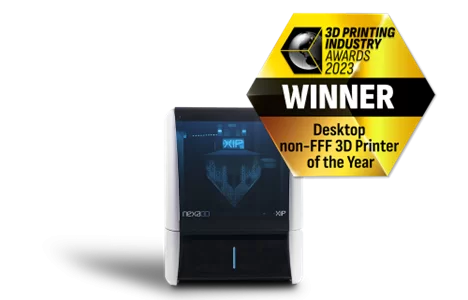 A product image of the Nexa3D XiP 3D printer with an award badge for "Desktop non-FFF 3D Printer of the Year, 2023," showcasing its compact and modern design.